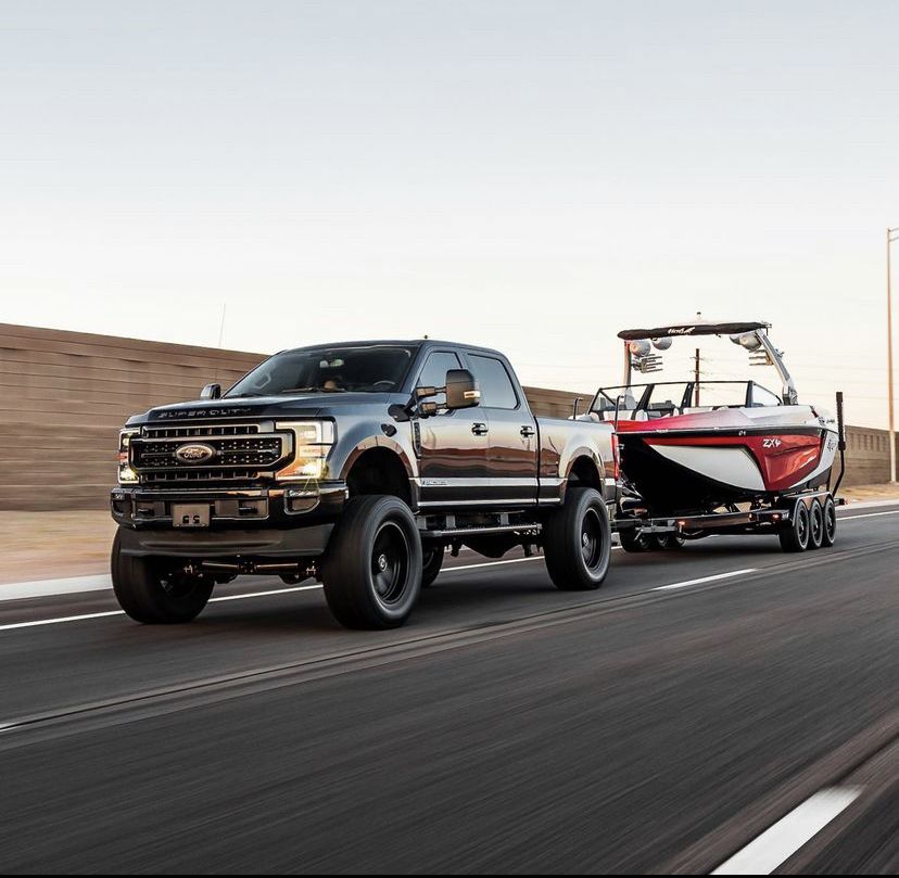 Pickup towing a wake boat on the highway